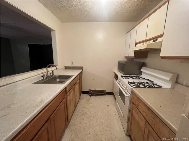 kitchen with range with two ovens, a textured ceiling, sink, and light tile floors