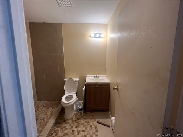 bathroom featuring vanity, walk in shower, tile floors, and toilet