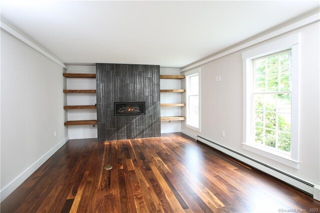 277 Ashley Falls Rd, North Canaan, CT 06018 - unfurnished living room featuring dark hardwood / wood-style floors, a tiled fireplace, baseboard heating, and a wealth of natural light