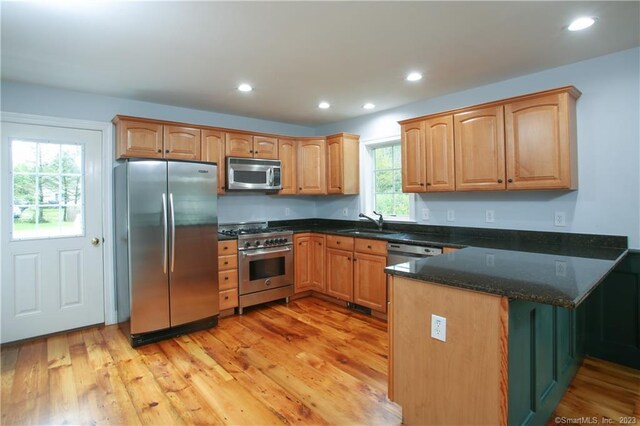 277 Ashley Falls Rd, North Canaan, CT 06018 - kitchen with stainless steel appliances, dark stone counters, kitchen peninsula, light hardwood / wood-style flooring, and sink