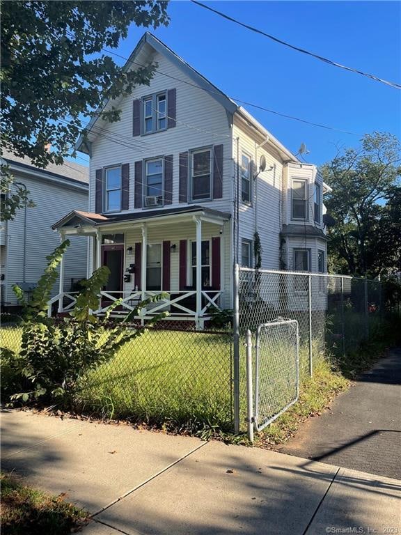 view of front of house with a porch and a front yard