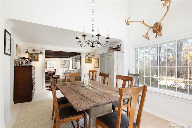 dining space with a chandelier, crown molding, and a wealth of natural light