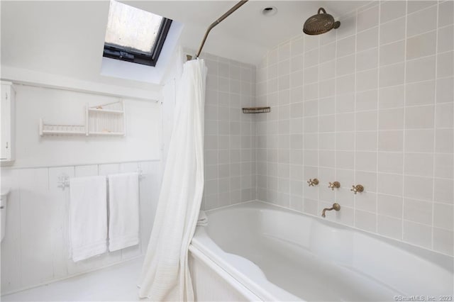 bathroom featuring a skylight and shower / tub combo with curtain