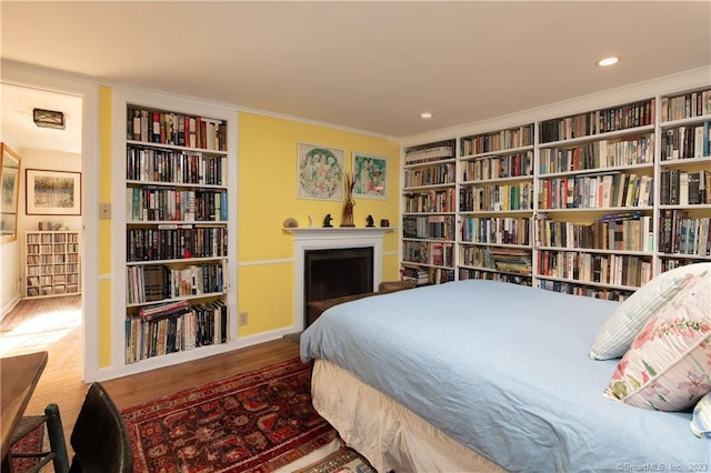 bedroom featuring wood-type flooring and crown molding