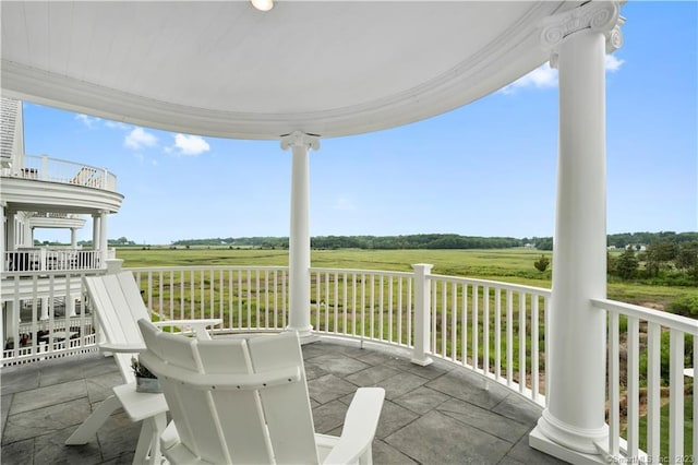 view of patio featuring a rural view and a balcony