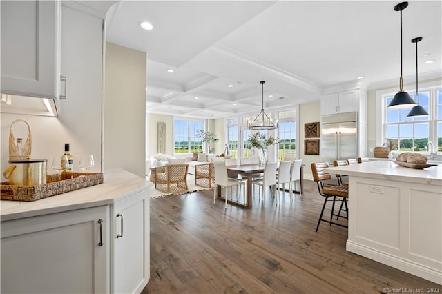 kitchen featuring coffered ceiling, dark hardwood / wood-style flooring, white cabinets, stainless steel built in fridge, and hanging light fixtures