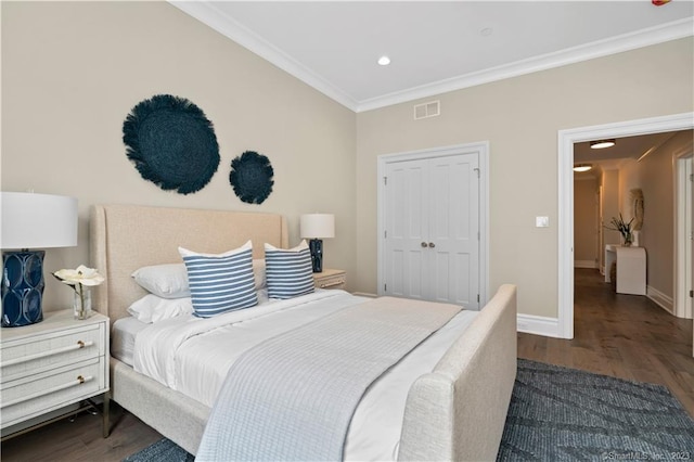 bedroom featuring crown molding, dark hardwood / wood-style floors, and a closet