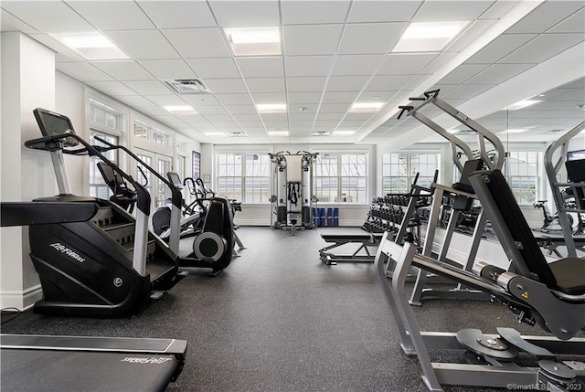 workout area with plenty of natural light and a drop ceiling