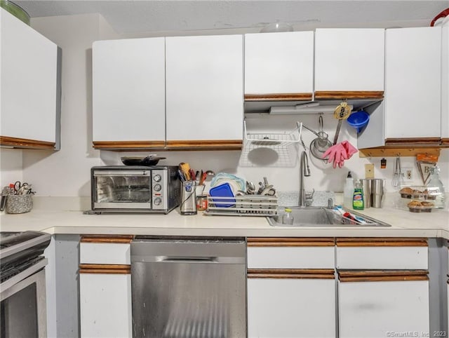 kitchen featuring stainless steel appliances, white cabinets, and sink