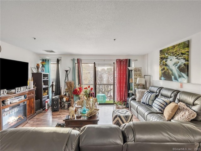 living room with light hardwood / wood-style flooring and a textured ceiling