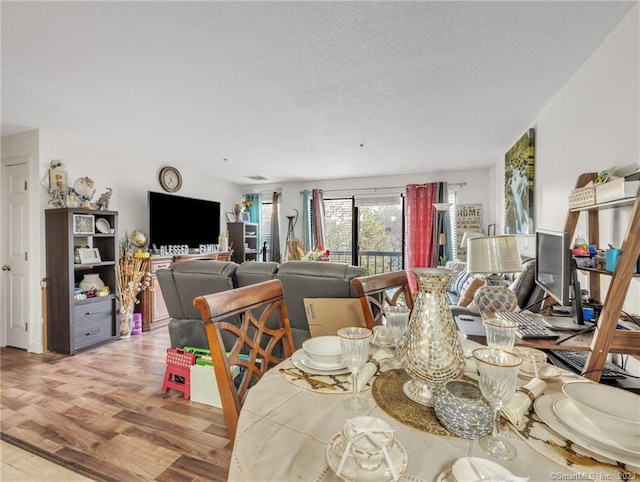 dining area featuring light hardwood / wood-style floors and a textured ceiling