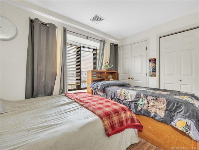 bedroom featuring multiple closets and hardwood / wood-style flooring