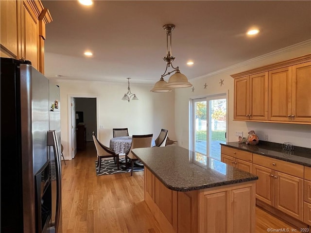 kitchen featuring stainless steel fridge, hanging light fixtures, light hardwood / wood-style floors, and a center island