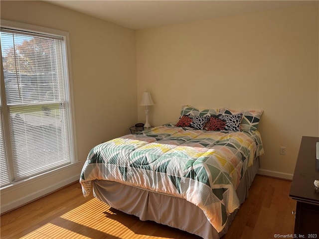 bedroom with multiple windows and light wood-type flooring