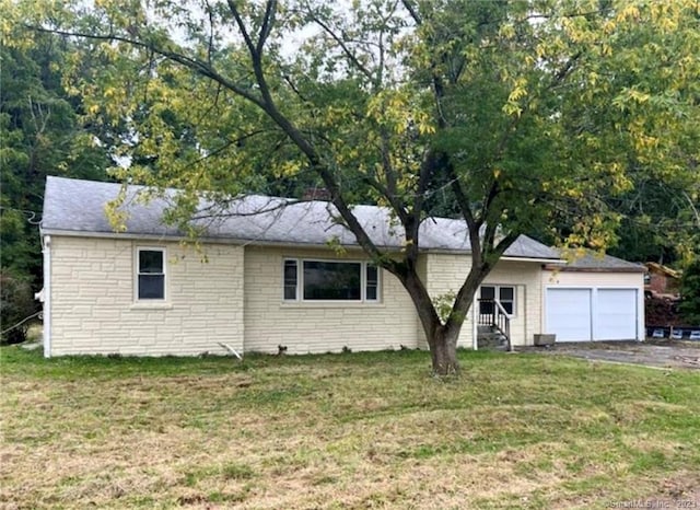 ranch-style house with a garage and a front lawn