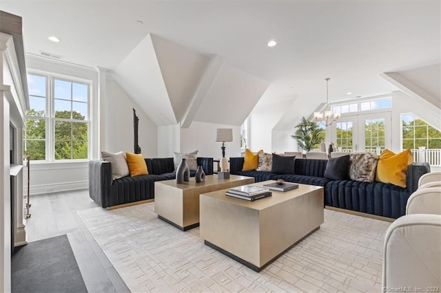 living room with light wood-type flooring, french doors, and vaulted ceiling