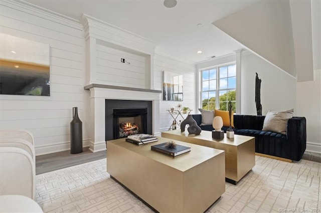 66 High St Unit 55, Guilford, CT 06437 - living area with crown molding, a warm lit fireplace, wooden walls, and recessed lighting