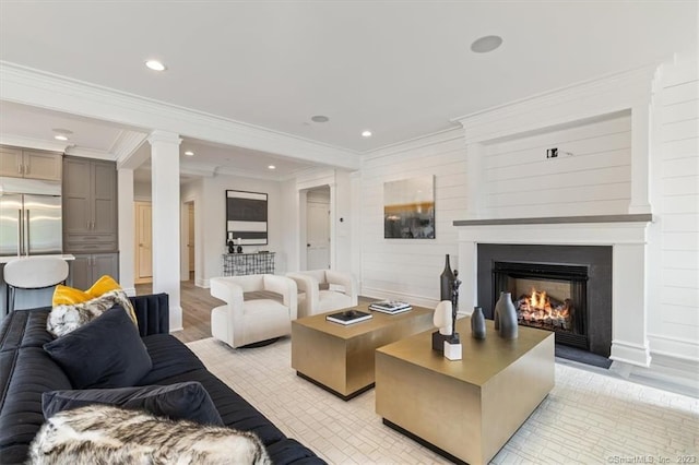 66 High St Unit 55, Guilford, CT 06437 - living room with a warm lit fireplace, light wood-style flooring, recessed lighting, ornamental molding, and ornate columns