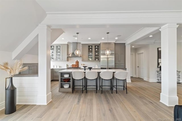 66 High St Unit 55, Guilford, CT 06437 - kitchen featuring wall chimney exhaust hood, built in fridge, a breakfast bar, light wood-style floors, and recessed lighting