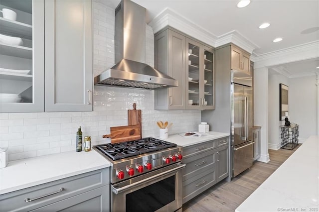 66 High St Unit 55, Guilford, CT 06437 - kitchen with wall chimney exhaust hood, premium appliances, gray cabinetry, crown molding, and light wood-type flooring