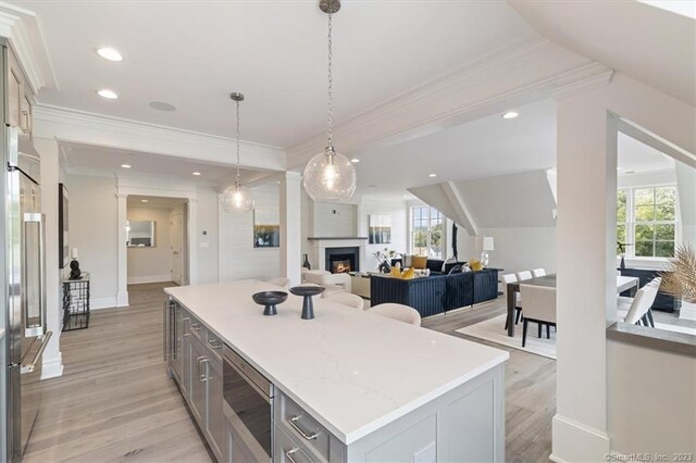 66 High St Unit 55, Guilford, CT 06437 - kitchen with built in appliances, gray cabinets, light wood finished floors, a kitchen island, and crown molding