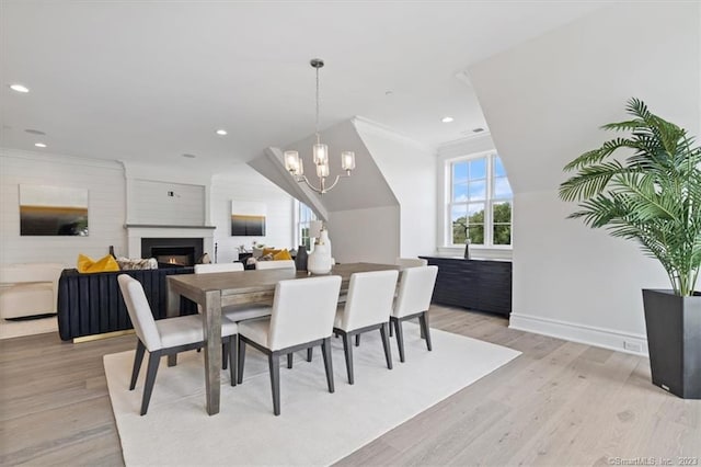 66 High St Unit 55, Guilford, CT 06437 - dining space featuring light wood-type flooring, a chandelier, a warm lit fireplace, recessed lighting, and lofted ceiling