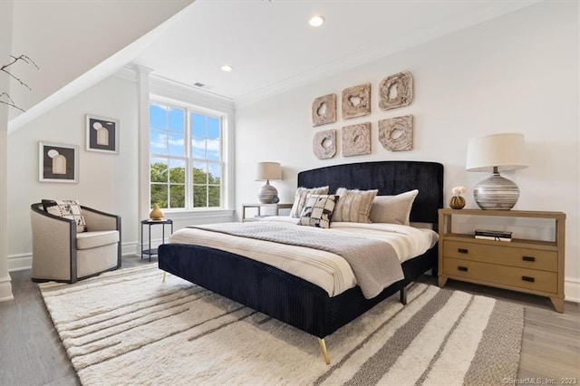 bedroom with hardwood / wood-style floors and ornamental molding