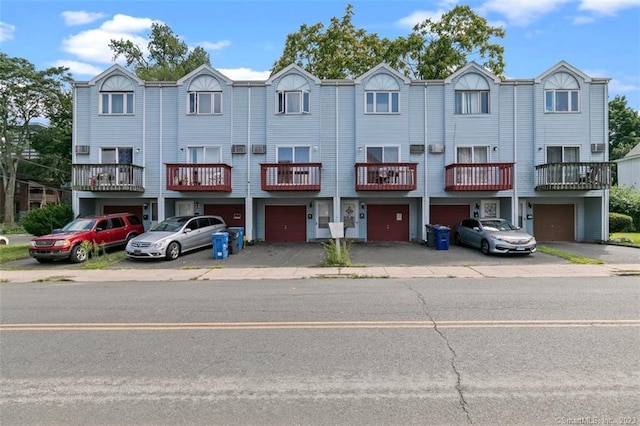 view of property with a balcony and a garage