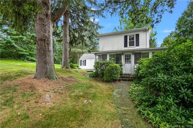 view of front of property with entry steps and a front lawn