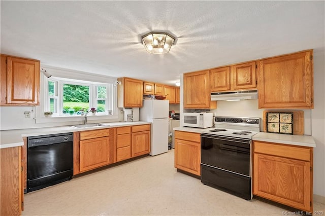 kitchen featuring under cabinet range hood, light countertops, white appliances, and a sink