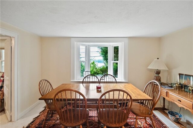 dining room with a textured ceiling and baseboards