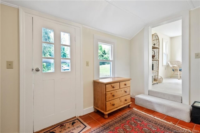 doorway to outside featuring dark tile patterned floors, lofted ceiling, and baseboards