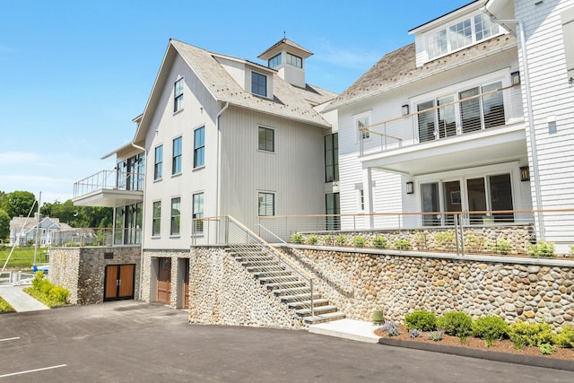 view of front of home with an attached garage, driveway, and stairway