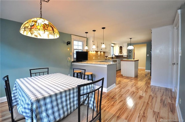 dining room with light hardwood / wood-style floors and sink