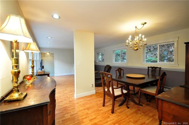 dining area with a notable chandelier and light hardwood / wood-style floors