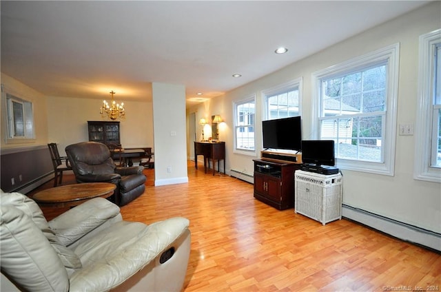 living room with an inviting chandelier, a baseboard heating unit, and light hardwood / wood-style floors