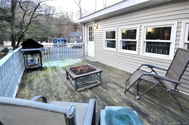 wooden deck with grilling area and an outdoor fire pit