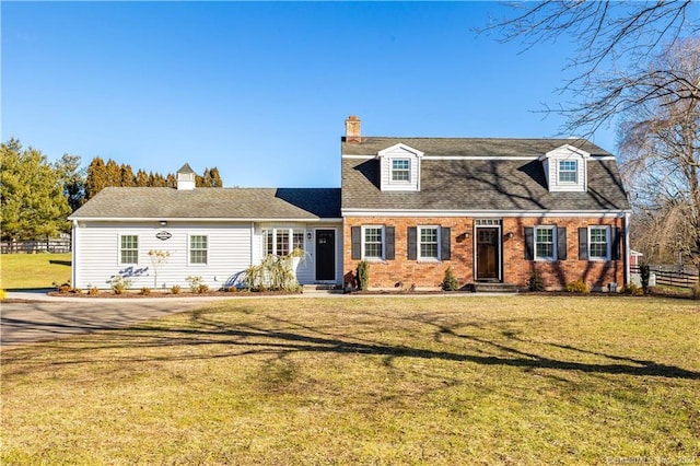 cape cod house featuring a front yard