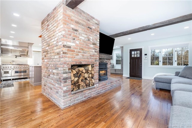 unfurnished living room featuring brick wall, a fireplace, and light wood-type flooring