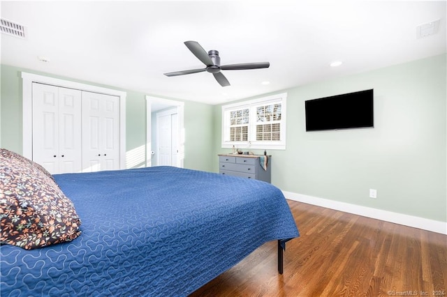 bedroom featuring ceiling fan, two closets, and wood-type flooring