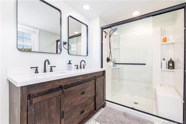 bathroom featuring a shower with door and double vanity