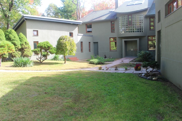 rear view of property with a lawn