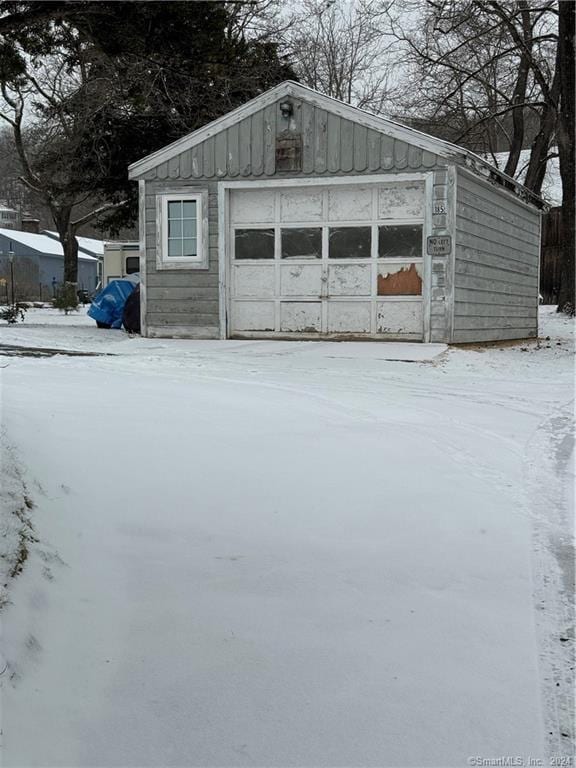 snow covered structure with a garage