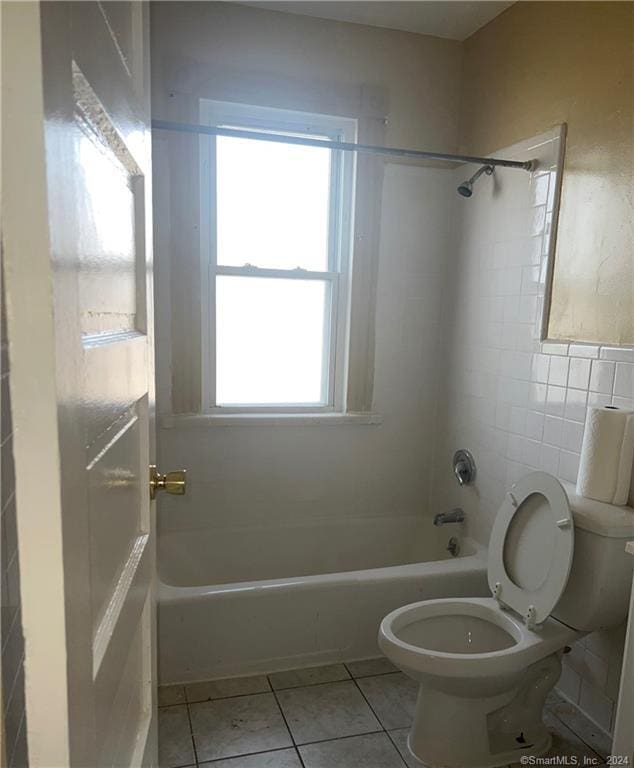 bathroom featuring tile flooring, toilet, and a healthy amount of sunlight