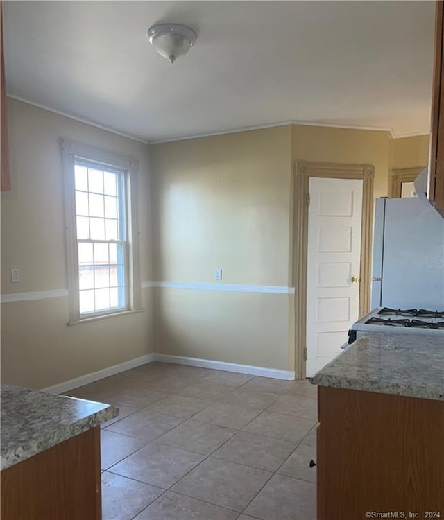 unfurnished dining area featuring light tile flooring