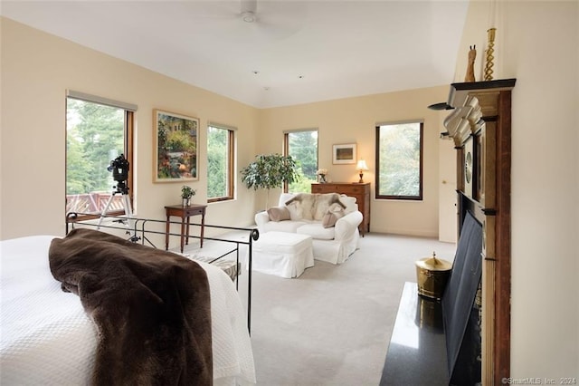 living room featuring light colored carpet, ceiling fan, and a fireplace