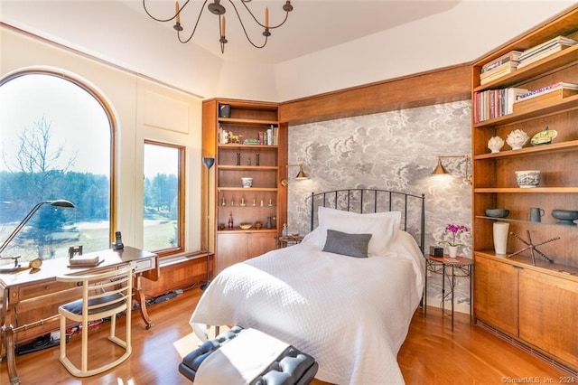 bedroom with a chandelier and light hardwood / wood-style floors