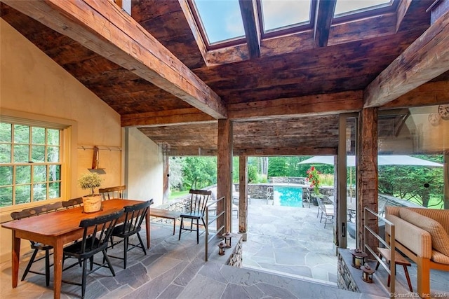 interior space featuring vaulted ceiling with skylight and wood ceiling