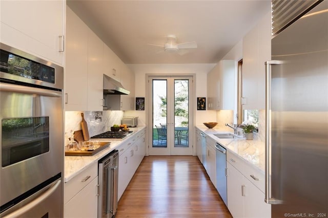 kitchen featuring white cabinets, ceiling fan, hardwood / wood-style flooring, and stainless steel appliances