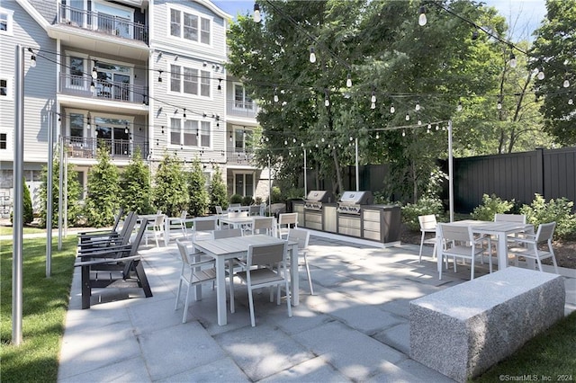 view of patio with a balcony, area for grilling, and exterior kitchen